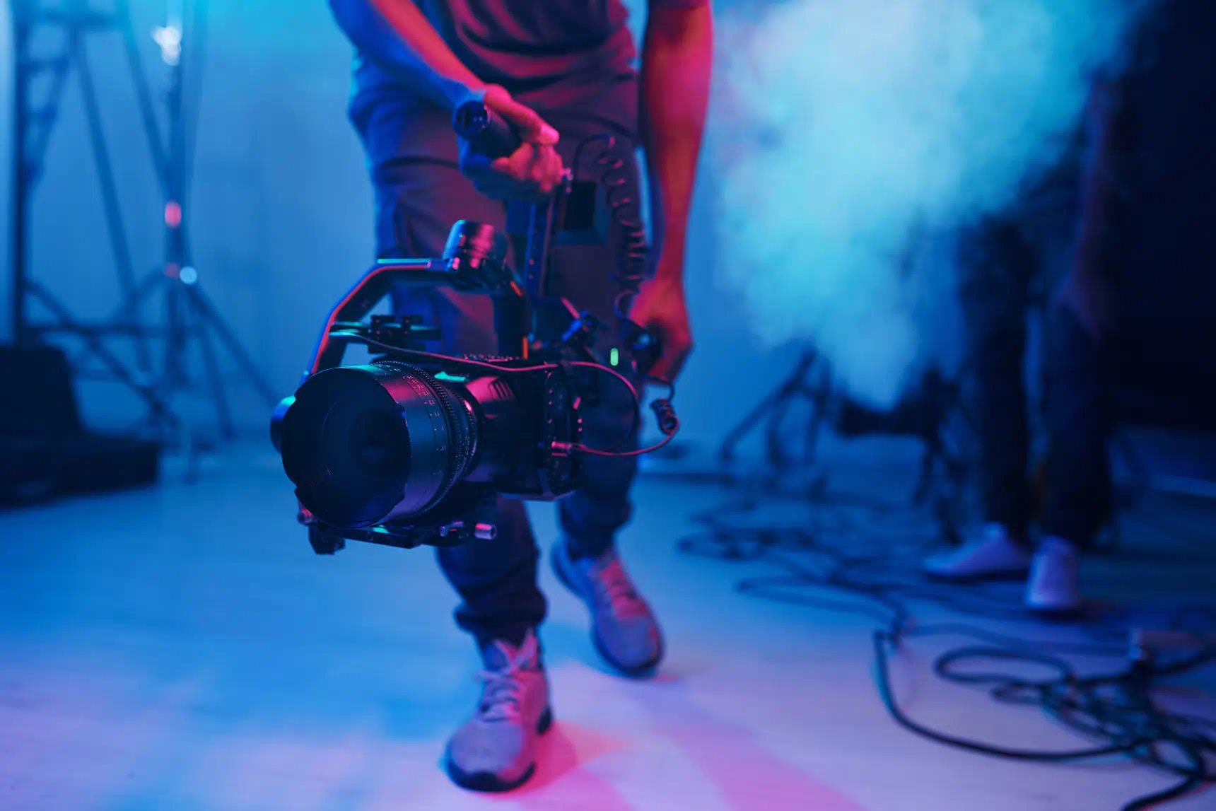 Kamera auf Gimbal filmt Musikvideo mit roter und blauer Farbstimmung und Nebel